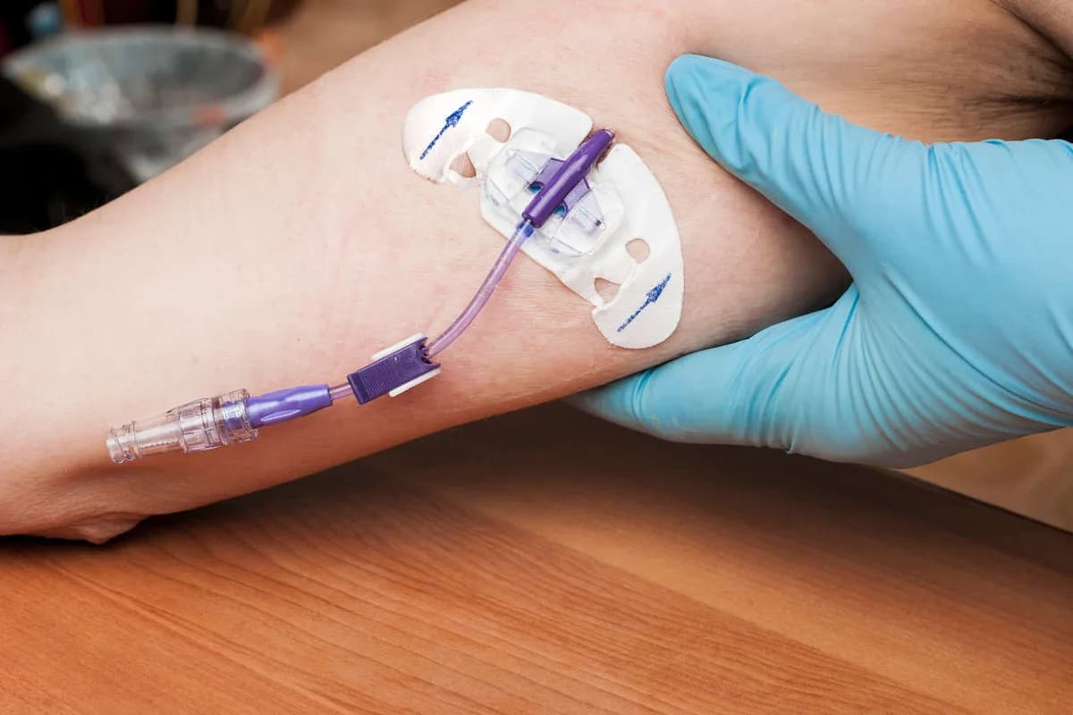 A PICC line dressing being secured on a patient's arm